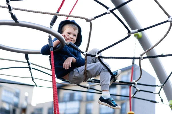 A little boy is having fun playing on the modern urban European playground — Stock Photo, Image