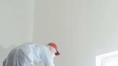 daire onarım - profesyonel ressam beyaz boya sprey tabancası ile duvarları boyar