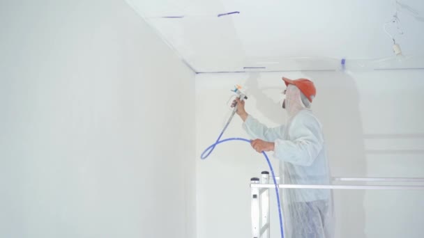 Ομορφιά αργή κίνηση. επισκευή του διαμερίσματος-επαγγελματία ζωγράφο ζωγραφίζει τους τοίχους με όπλο σπρέι λευκής μπογιάς — Αρχείο Βίντεο