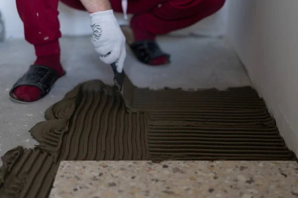 Reparation och dekoration av lägenheter och hus. Proffs lägga Porslin kakel på golvet i Bad rums. — Stockfoto