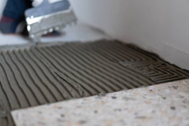 Onarım ve daire ve evlerin dekorasyonu. Profesyoneller banyoda yere porselen fayans yatıyordu.