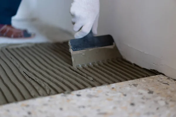 Επισκευή και διακόσμηση των διαμερισμάτων και των σπιτιών. Οι επαγγελματίες να θέσει πλακάκια πορσελάνης στο πάτωμα στο μπάνιο. — Φωτογραφία Αρχείου