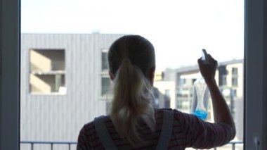 Pencereyi temizleyen genç kadın.