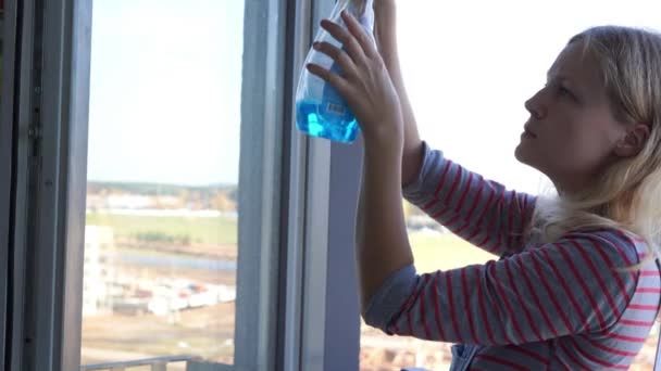 Mujer joven limpiando la ventana — Vídeos de Stock