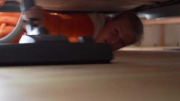 침실 침대 밑 바닥을 진공청소기로 청소하는 여자 — 비디오