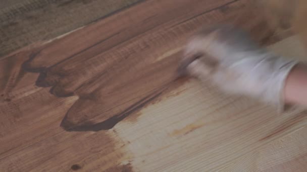 Réparation et décoration. le maître applique un revêtement respectueux de l'environnement sur le plancher en bois - cire d'huile naturelle sombre — Video