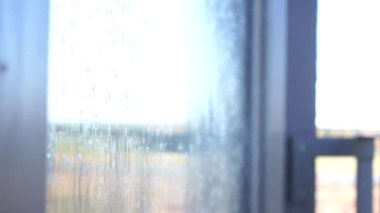 Pencereyi temizleyen genç kadın, ağır çekimde.