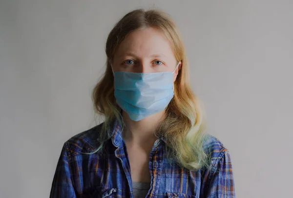 Protecção contra o coronavírus. mulher coloca uma máscara em seu rosto . — Fotografia de Stock