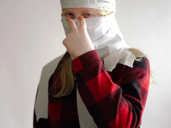 面白い写真-コロナウイルスの流行により隔離されました。灰色の背景にポーズをとったトイレットペーパーのマスクの女の子. — ストック写真
