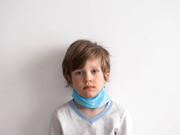 Protección contra el coronavirus. pequeño niño pone una máscara en su cara . —  Fotos de Stock