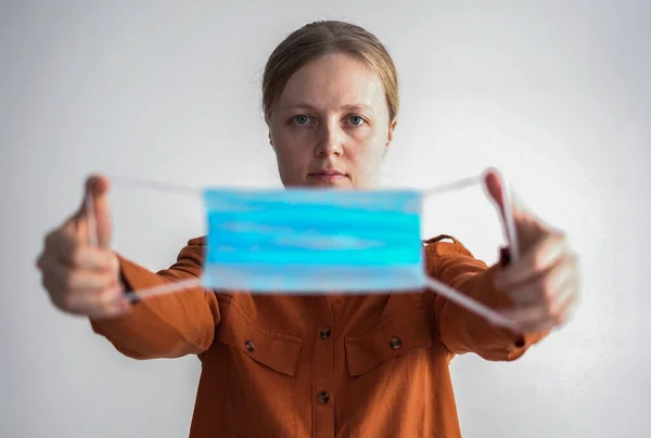 Protecção contra o coronavírus. mulher coloca uma máscara em seu rosto . — Fotografia de Stock