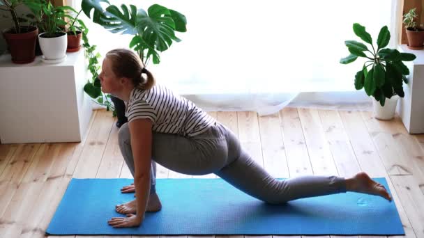 Fica em casa. mulher mascarada fazendo ioga na sala de estar durante a quarentena, exercício saudação ao sol — Vídeo de Stock