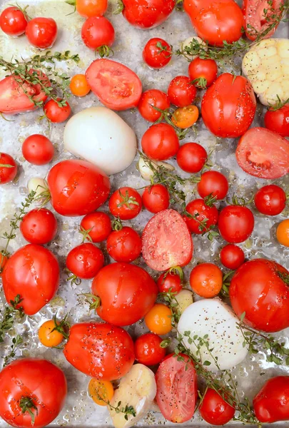 Sheet pan of roasted tomatoes, garlic, herbs and olive oil