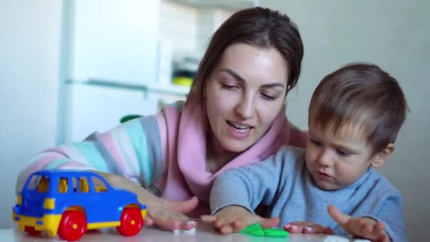 自宅成形粘土と一緒に遊ぶから母と子供の少年. — ストック動画