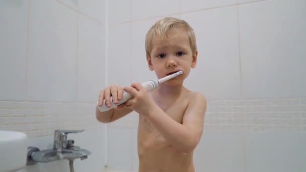 Lindo chico en el baño lavándose los dientes — Vídeo de stock