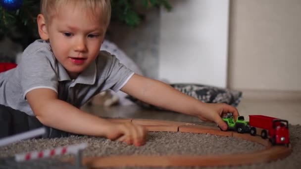 Niño jugando ferrocarril juguete — Vídeo de stock