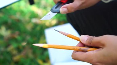 Kadın ressam kalemleri sivri bıçak ve yakın plan ile açıyor..