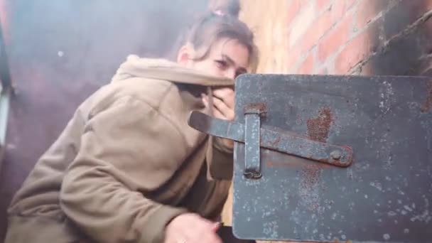 Rus genç kadın ocağa odun atıyor. — Stok video