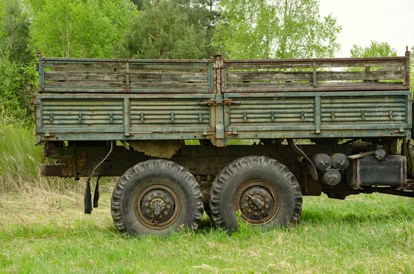 Bed of a green military vehicle on green grass field
