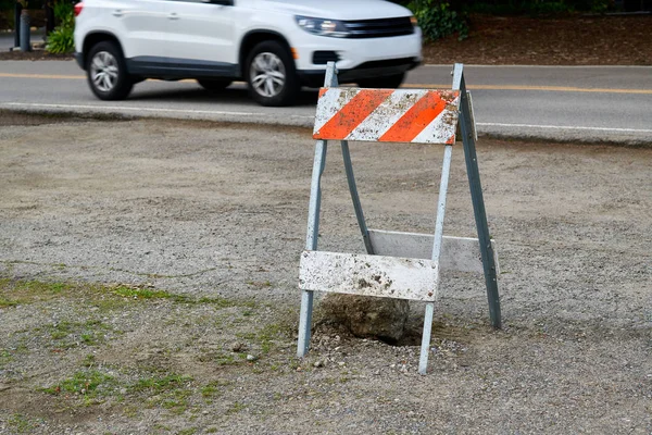 Barricada de construção com um carro branco no fundo — Fotografia de Stock