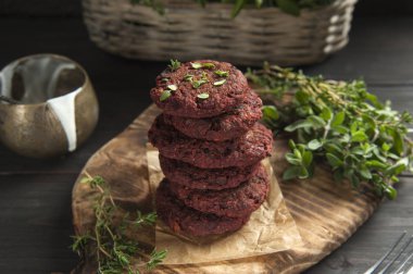 Baharatlı otlar ile Vegan pirzola ahşap bir tahta üzerinde servis edilir. Yakında ekşi krema ve hasır sepetli bir sos teknesi var..