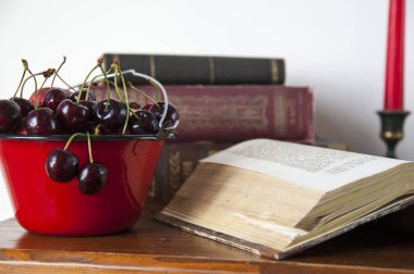 Çekmeceeski bir göğüs che ile kırmızı bir emaye kase var