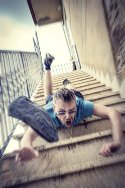 Man falling down the stairs and losing his hat