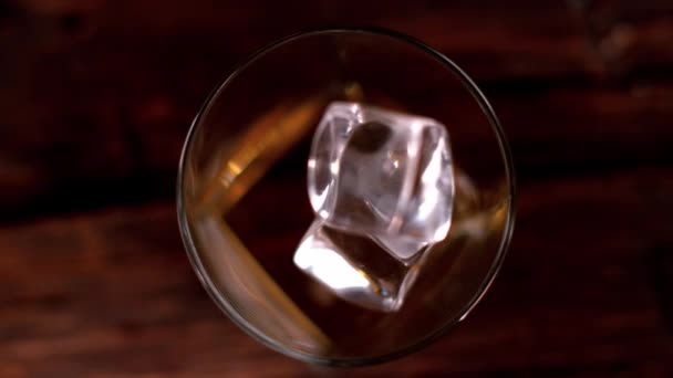 Super lent mouvement de chute de glaçon dans le verre de whisky, vue de dessus. Filmé sur caméra cinéma ralenti, 1000fps 