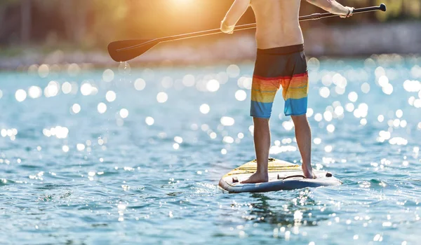 Paddleboard に立っている若い人の詳細です Paddleboarding 輸送と水活動スポーツの現代の方法は します — ストック写真