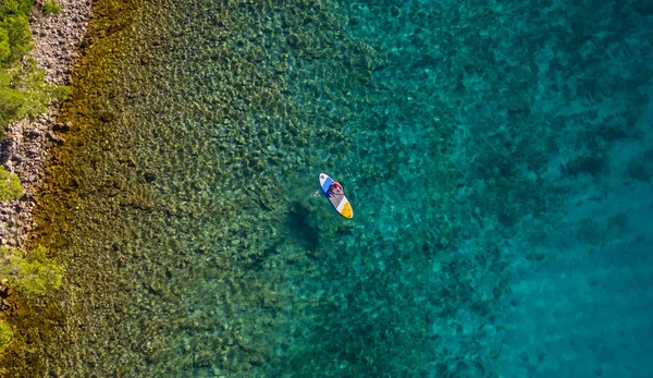 Paddleboard に乗って若い男の空撮 Paddleboarding 輸送と水活動スポーツの現代の方法は します — ストック写真