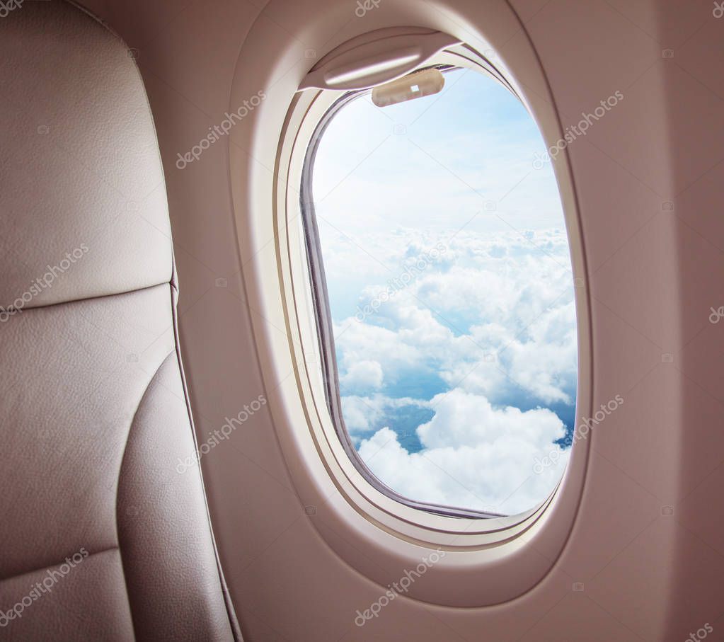 Airplane interior with window view of clouds. Concept of travel and air transportation