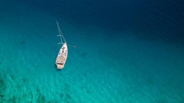 Açık denizde yüzen bir tekne, hava manzaralı. Aktif yaşam tarzı, su taşımacılığı ve deniz sporu.