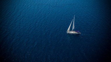 Açık denizde yüzen bir tekne, hava manzaralı. Aktif yaşam tarzı, su taşımacılığı ve deniz sporu.