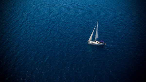 Sailing boat on open water, aerial view. Active life style, water transportation and marine sport.