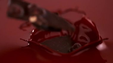 Süper ağır çekim düşen parça çikolata bar sıcak çikolatanın içine düşüyor. Sinema yüksek hızlı kamera, 1000 fps ile filme.