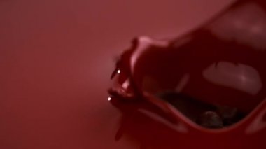 Süper ağır çekim düşen parça çikolata bar sıcak çikolatanın içine düşüyor. Sinema yüksek hızlı kamera, 1000 fps ile filme.