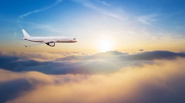 Detail of side view of commercial airplane flying above clouds. Panoramic size