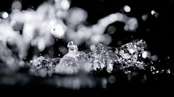 Mouvement super lent de l'eau coulant sur fond noir .