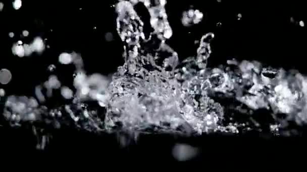 Super slow motion vatten hälla på svart bakgrund. — Stockvideo