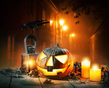 Korkunç korku arka plan ile halloween balkabağı jack o fener, ahşap güverte üzerinde yerleştirilir. Eski şehir sokak parlayan lambalar zemin üzerine. Cadılar Bayramı ürkütücü arka plan.