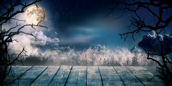 Scary horror background with empty wooden deck, ready for product placement. Halloween spooky background.