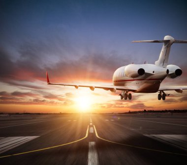 Private jet plane landing on runway in beautiful sunset light. Modern and fastest mode of transportation, business and succesfull style of life. clipart