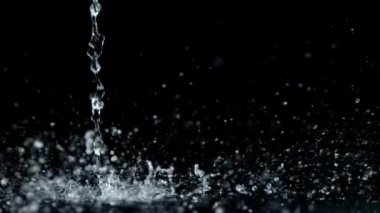Siyah arka planda izole edilmiş çok yavaş su sıçratma hareketi. Çok hızlı bir kamerayla çekildi, 1000 fps.