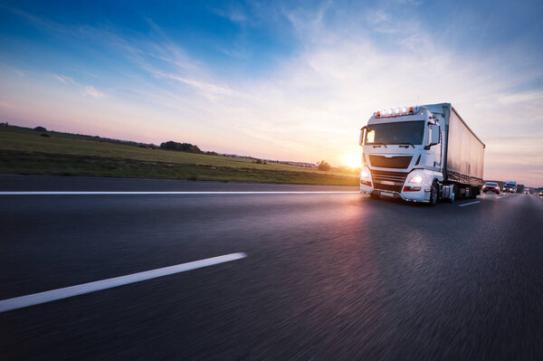 Loaded European truck on motorway in sunset