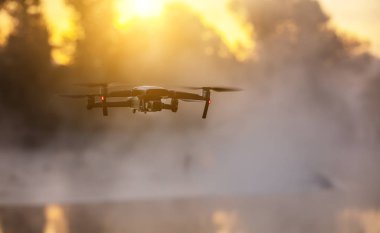 Digital fotoğraf makinesi ile helikopter robot, Nehri üzerinde arka plan bulanıklık. Modern teknoloji, İHA kavramı. Güzel açık olmayan kentsel sahne.