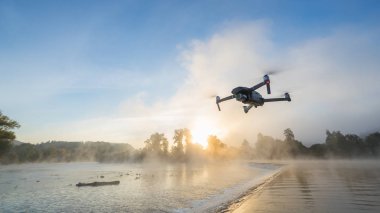 Digital fotoğraf makinesi ile helikopter robot, Nehri üzerinde arka plan bulanıklık. Modern teknoloji, İHA kavramı. Güzel açık olmayan kentsel sahne.
