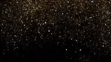 Süper ağır çekim altın ışıltılı, parçacıklar siyah arka plan üzerine, odak derinliği sığ. Yüksek hız sinema Kamerası, 1000 fps üzerinde filme.