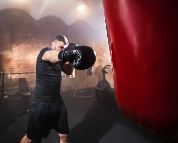 Young Man Hitting Punching Bag Training Lesson Dark Industrial Fitness — Stock Photo, Image