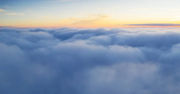 Beautiful sunrise cloudy sky from aerial view. Airplane view above clouds