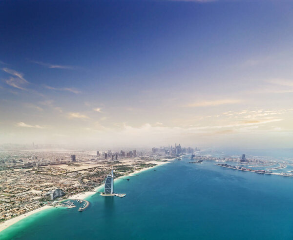Aerial view of Dubai shore downtown with palm island on background. Panoramic view of modern city.